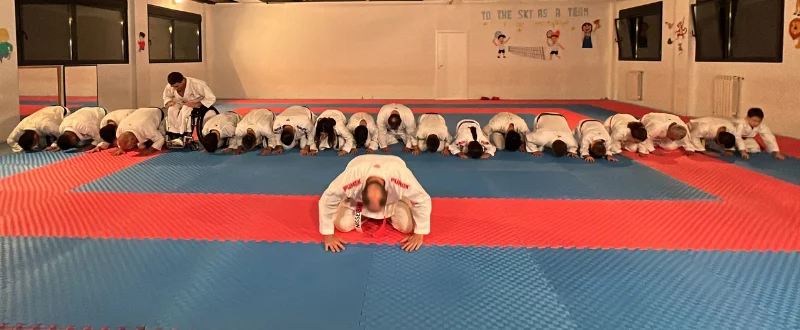 Santi Sánchez y alumnos arrodillados en clase de karate