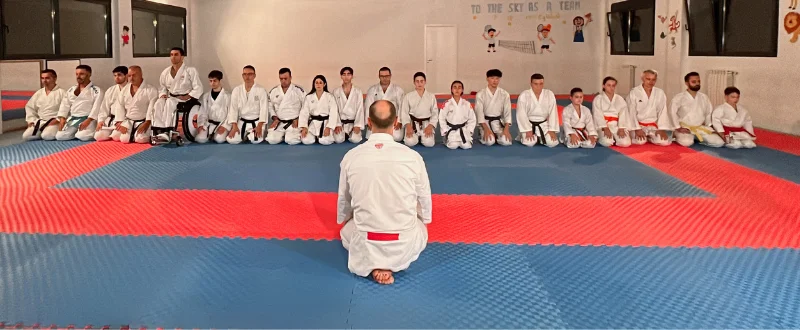 Santi Sánchez y alumnos de rodillas en clase de karate
